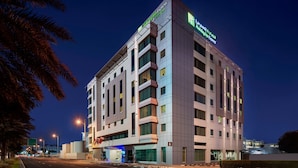 Un hôtel à plusieurs étages au design moderne, avec une enseigne bien visible indiquant qu’il s’agit d’un Holiday Inn Express.