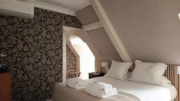 Una camera d'albergo con un letto, un comodino, una lampada e una parete decorata con un motivo floreale.