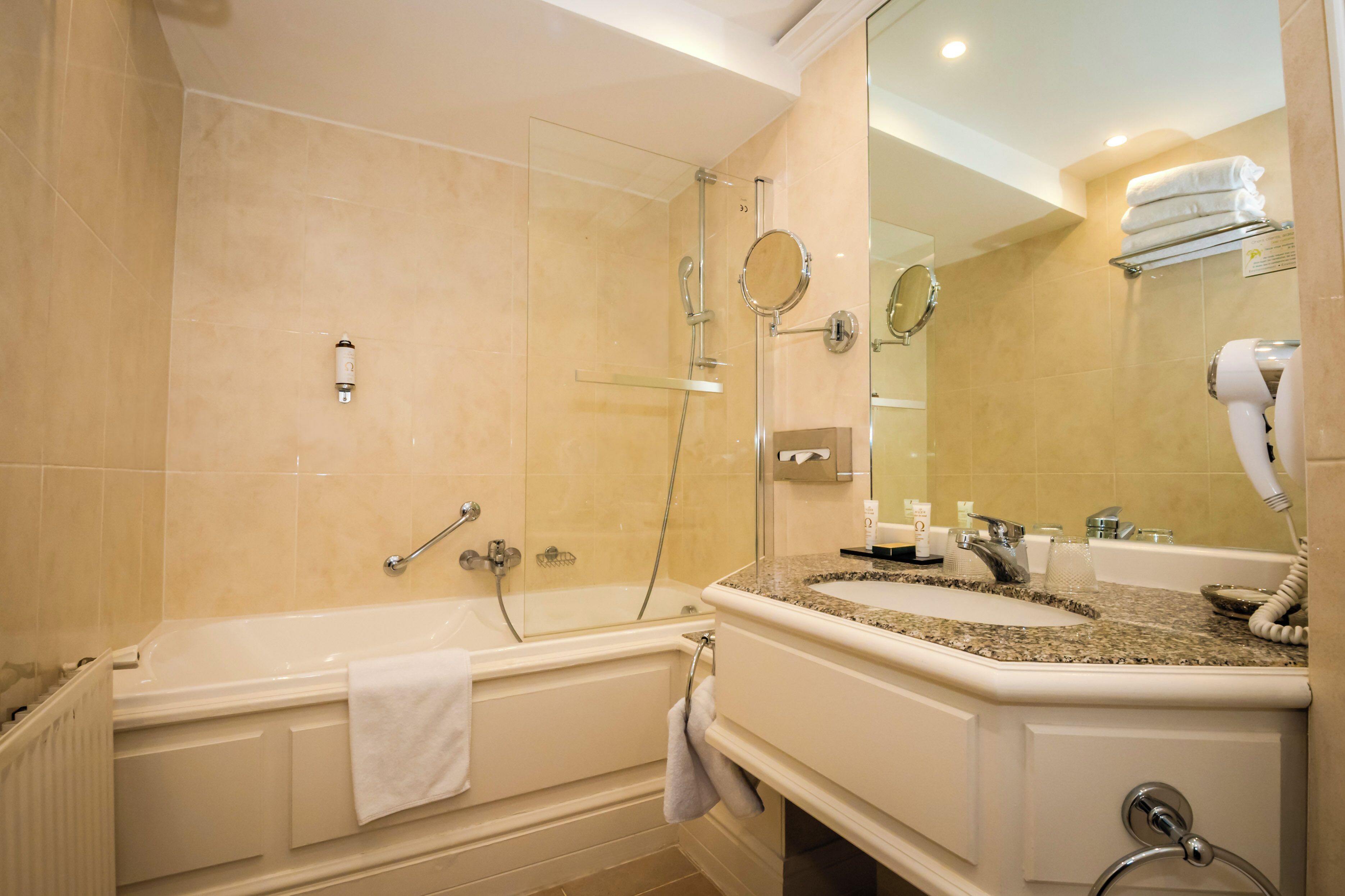 A bathroom with a bathtub, a sink with a mirror, and a towel rack.