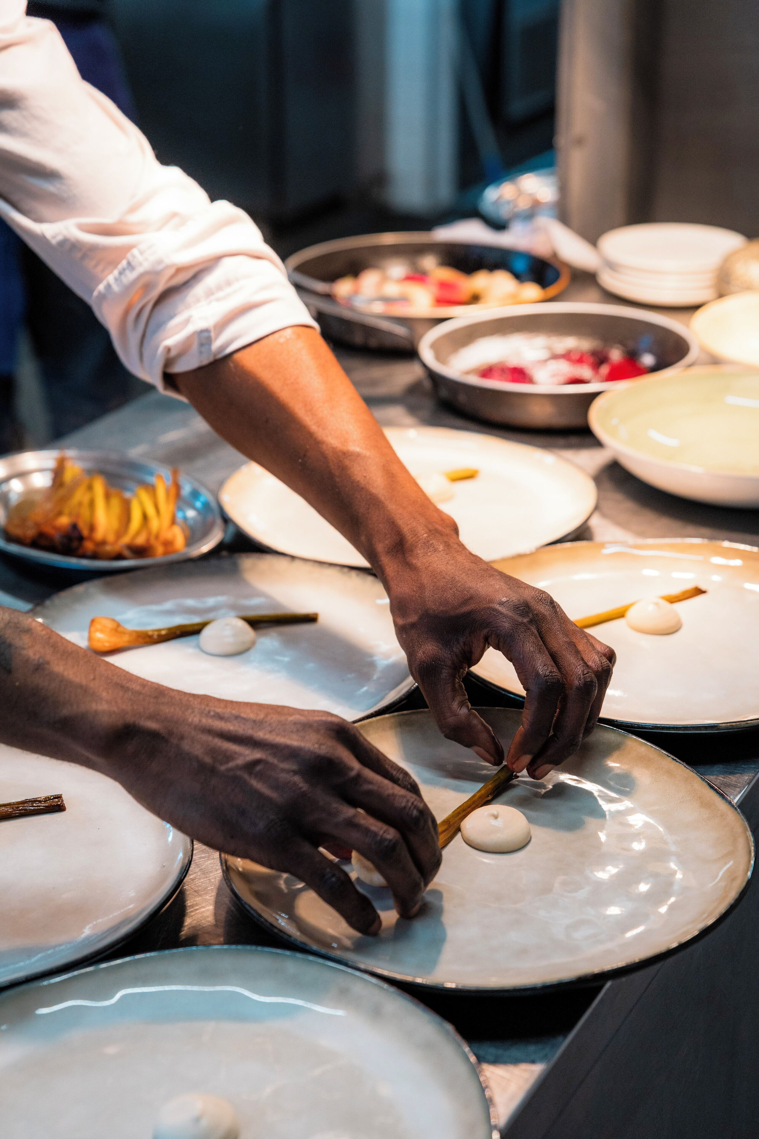 A person serving food from a bowl onto plates.