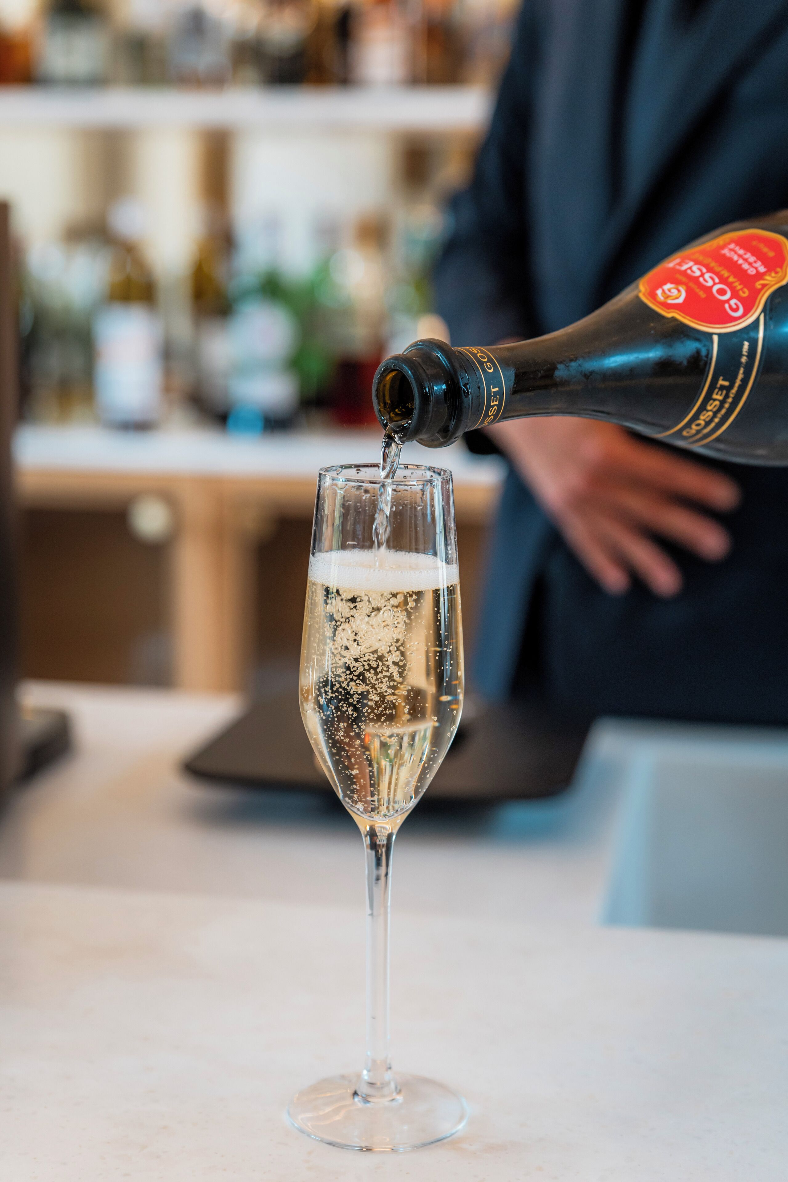 A bottle of champagne being poured into a glass.