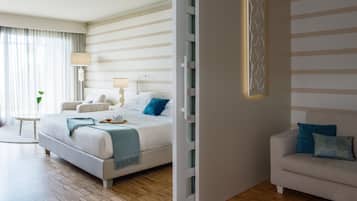 Ein modernes Hotelzimmer mit einem großen Bett, Nachttischen und einer Sitzecke mit einer Couch.