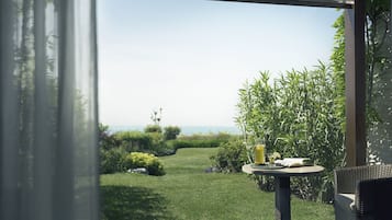 Un patio con una mesa, una silla y vista al mar.