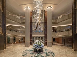 A spacious lobby with a central floral arrangement, high ceilings, and a modern chandelier. - Sofitel Bangkok Sukhumvit (Bangkok)