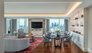 Un salon moderne avec vue sur la ville, un téléviseur à écran plat, un coin repas et une bibliothèque.