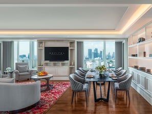 Un salon moderne comprenant un coin repas, un téléviseur à écran plat et une vue sur la ville.