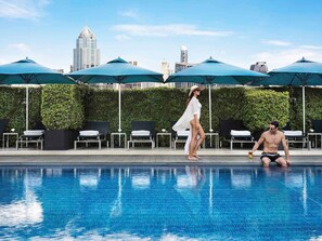Una piscina al aire libre, sombrillas