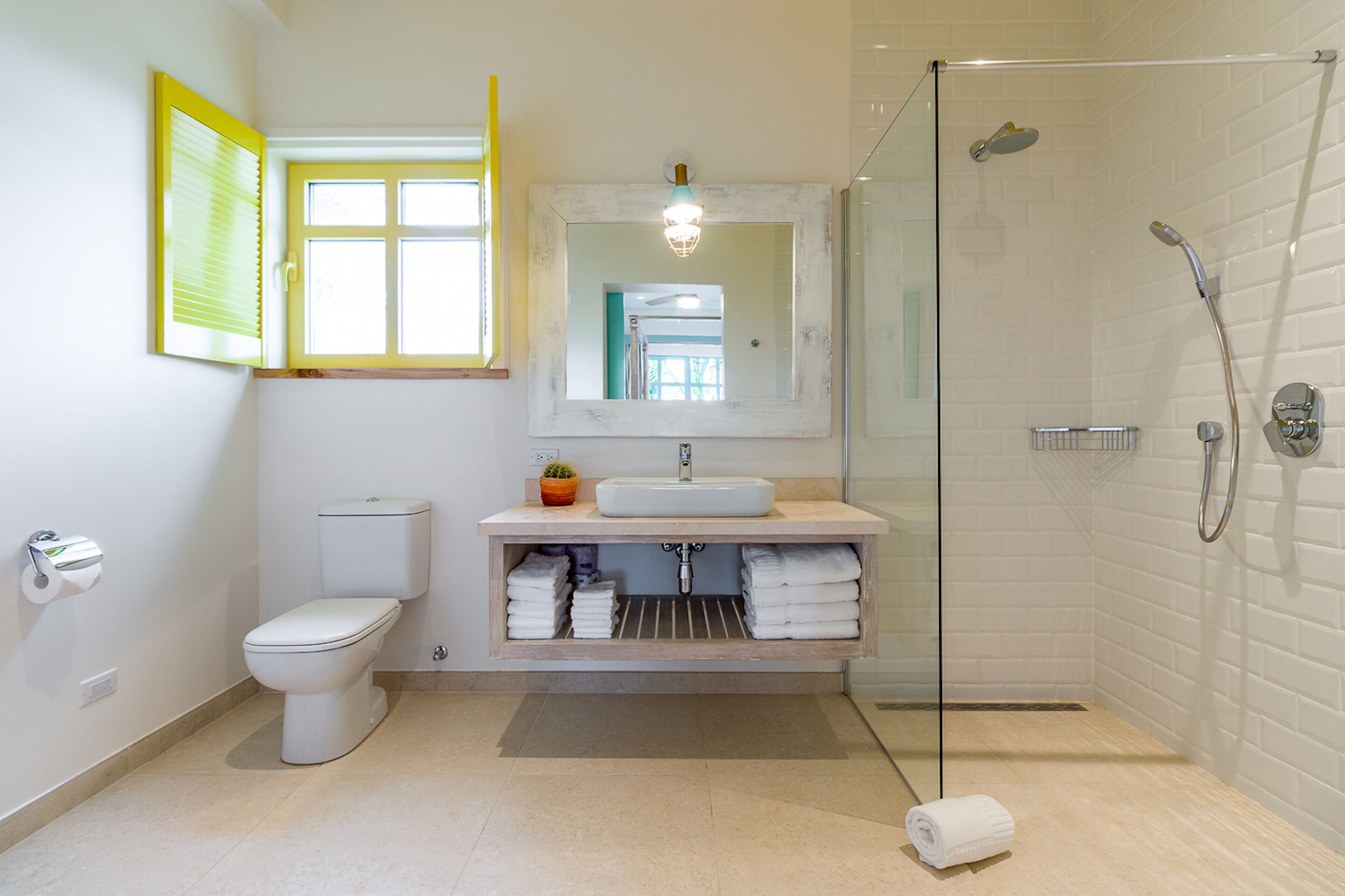 Et moderne badeværelse med toilet, håndvask og brusebad.