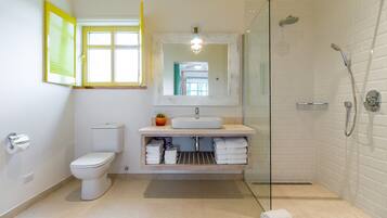 Et moderne badeværelse med toilet, håndvask og brusebad.
