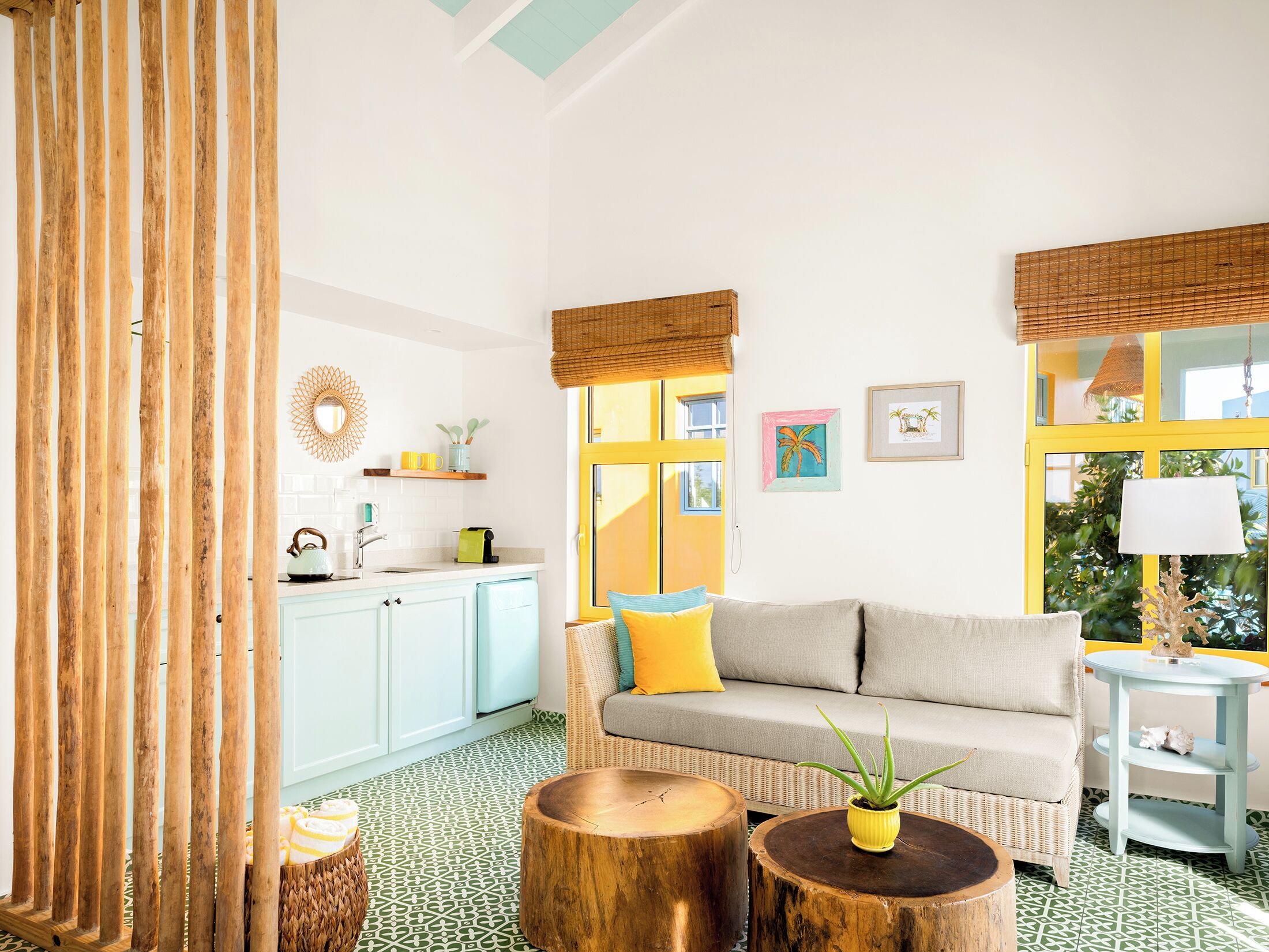 A bright living room with a sofa, coffee table, and a dining area with a table and chairs.