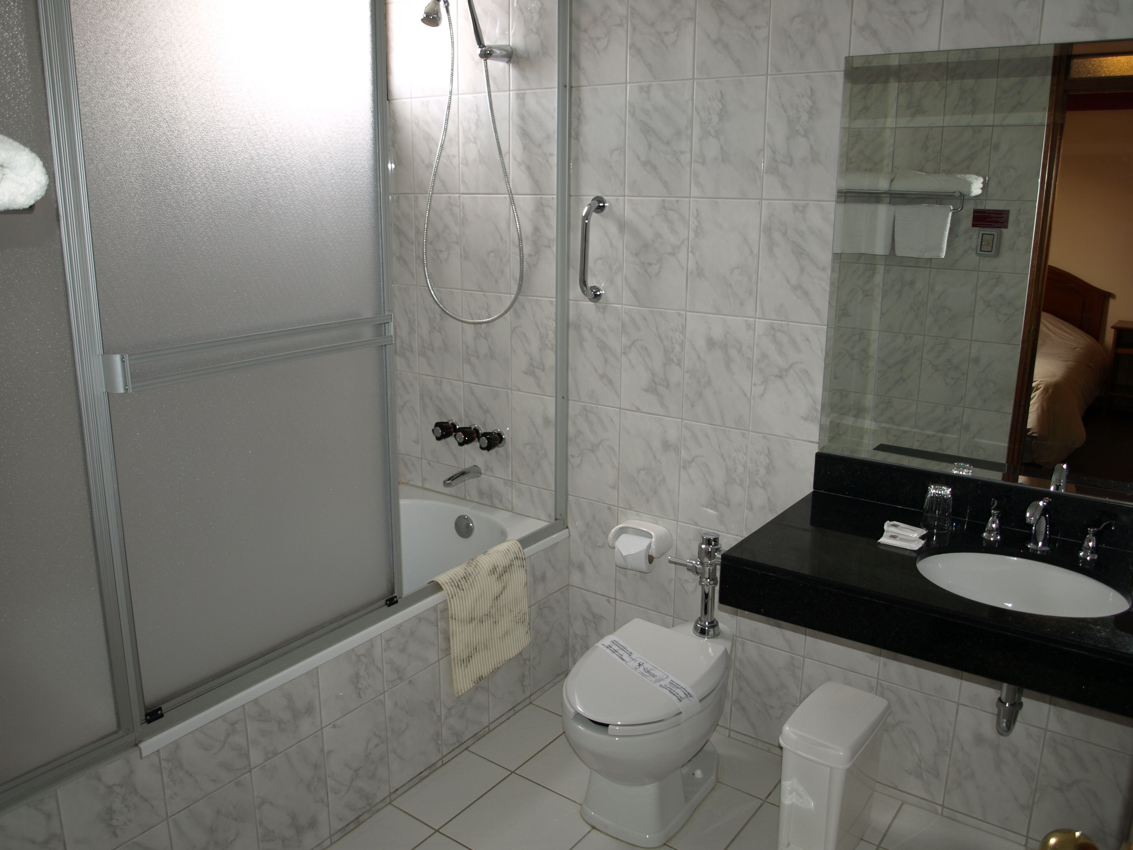 A bathroom with a bathtub, toilet, and sink.