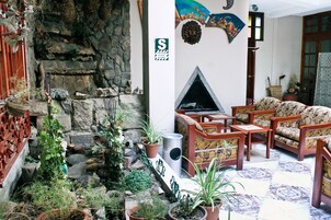 Una sala de estar acogedora con chimenea, asientos cómodos y una pared de piedra.
