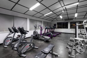 A gym with treadmills, elliptical machines, and weightlifting equipment.