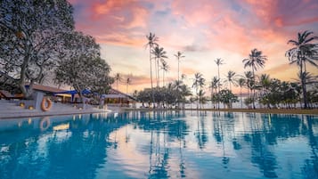 Una piscina al aire libre, sombrillas, sillones reclinables de piscina