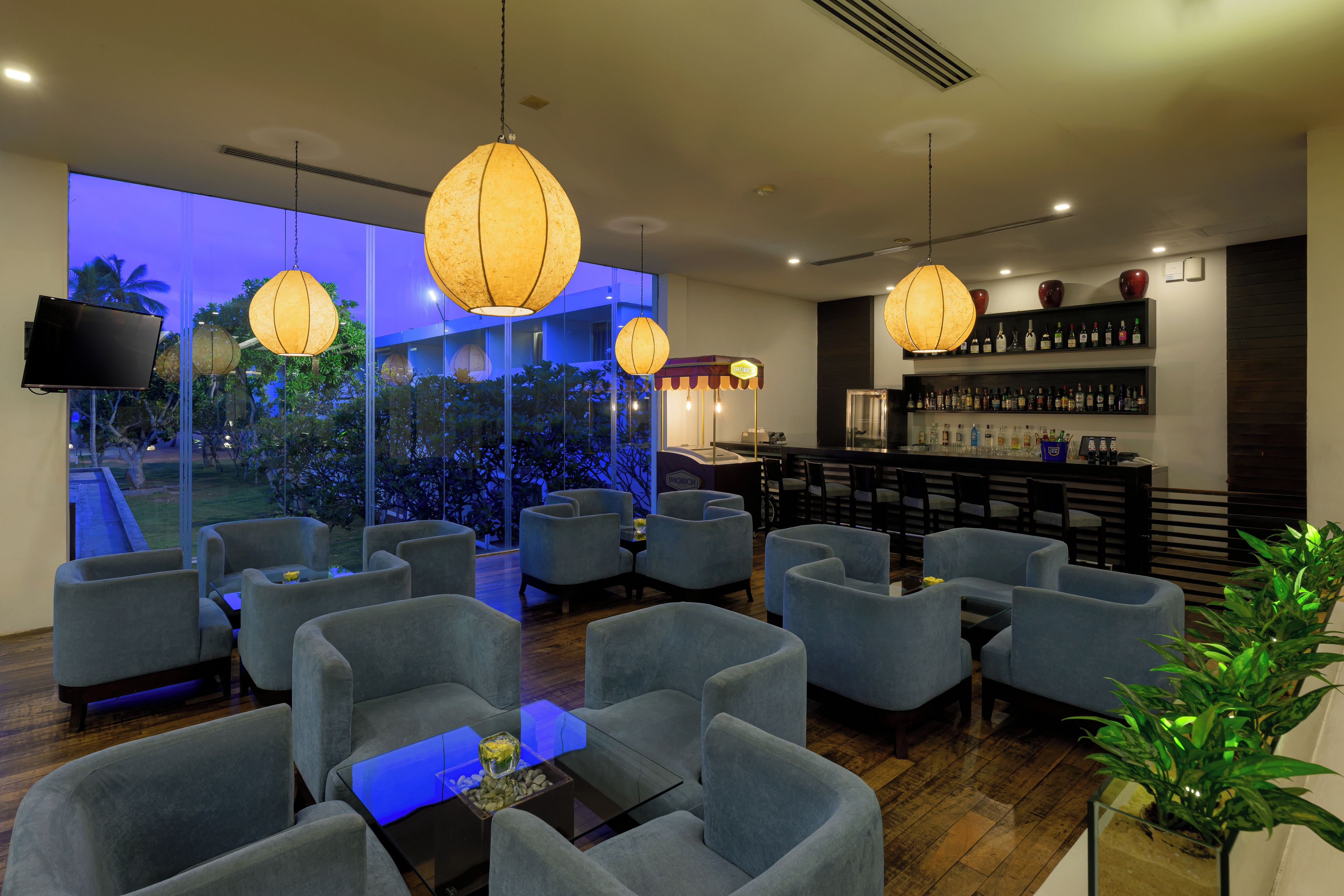 A modern bar area with seating and a wine display.