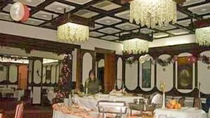 A banquet hall with tables set for a formal event, featuring a high ceiling with chandeliers and ornate wall decorations. - Hotel Kasina (Belgrade)