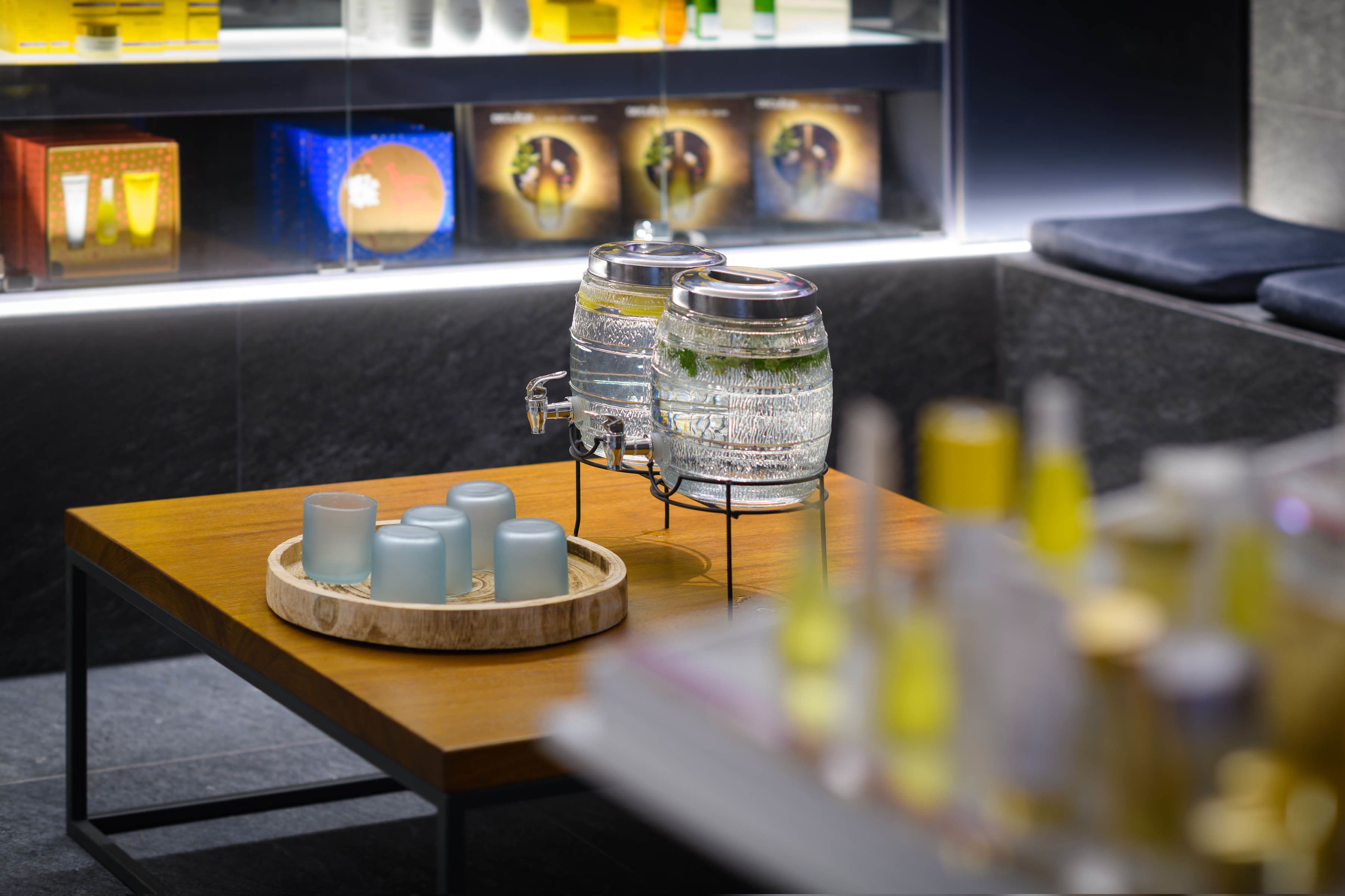 Un espace bar avec une table en bois, un distributeur d’eau et des bougies.