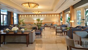A spacious lobby with a central seating area, large windows, and a decorative wall mural. - Ajax Hotel (Limassol)