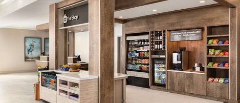 A coffee shop with a wooden interior, a refrigerated display case, and a variety of snacks and beverages.