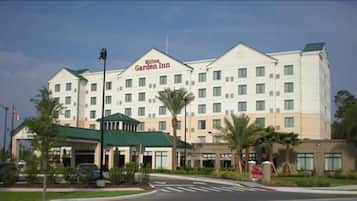 A large hotel with a prominent Garden Inn sign, multiple floors, and a green-roofed entrance.