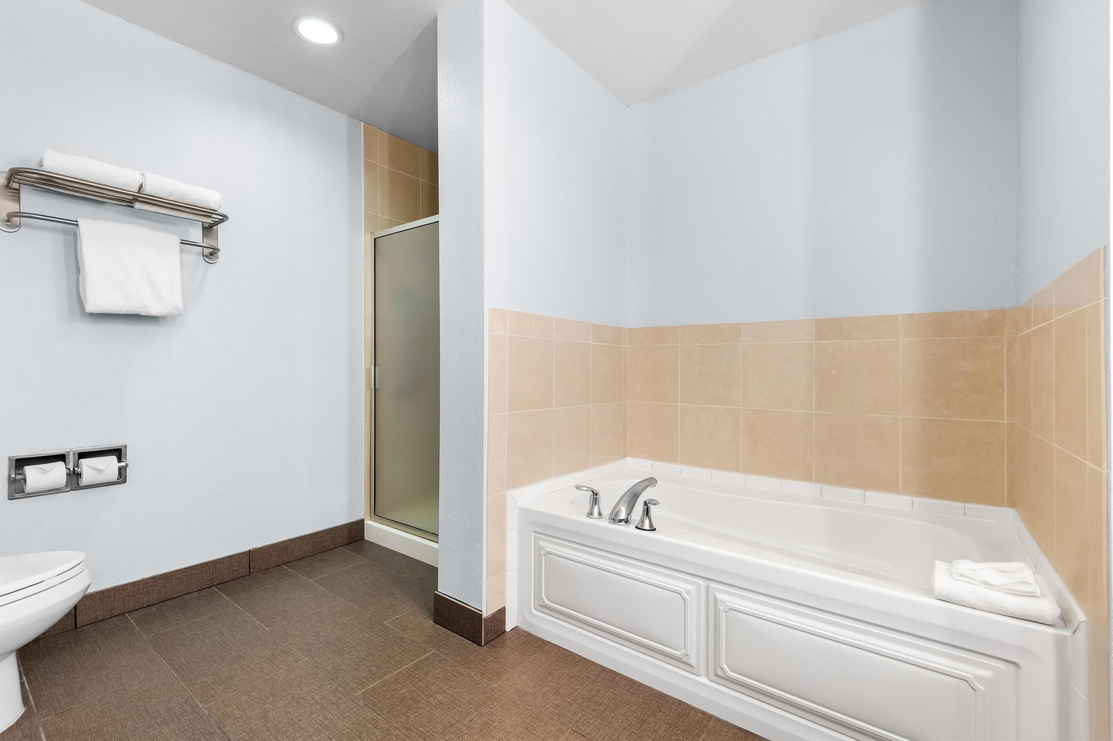 A modern bathroom with a toilet, a sink, a bathtub, and a shower.