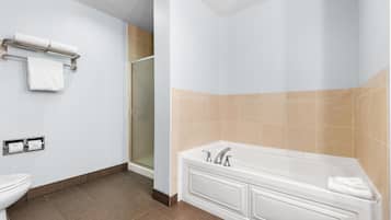 A modern bathroom with a toilet, a sink, a bathtub, and a shower.