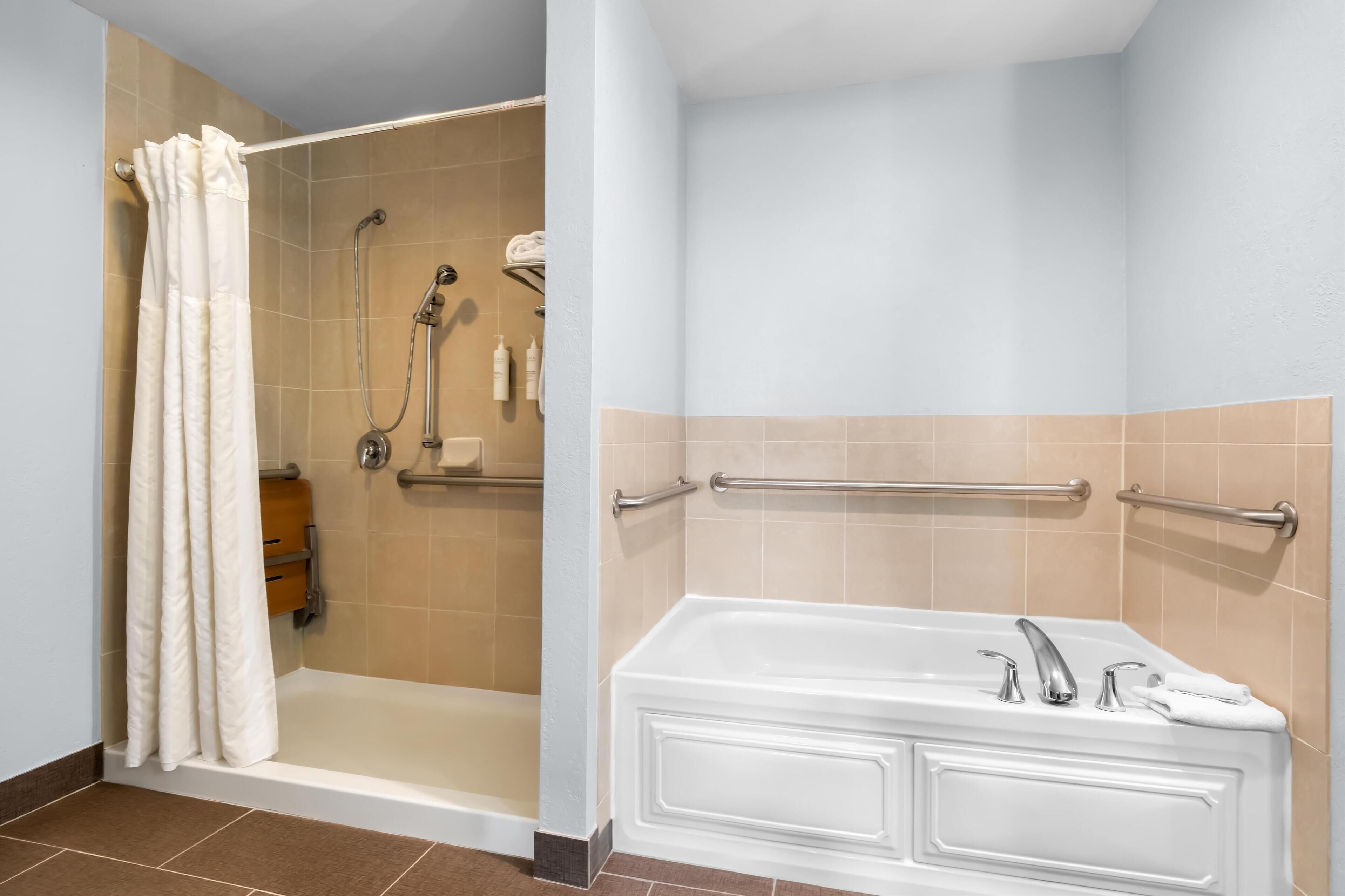 A bathroom with a shower, a bathtub, and a toilet.