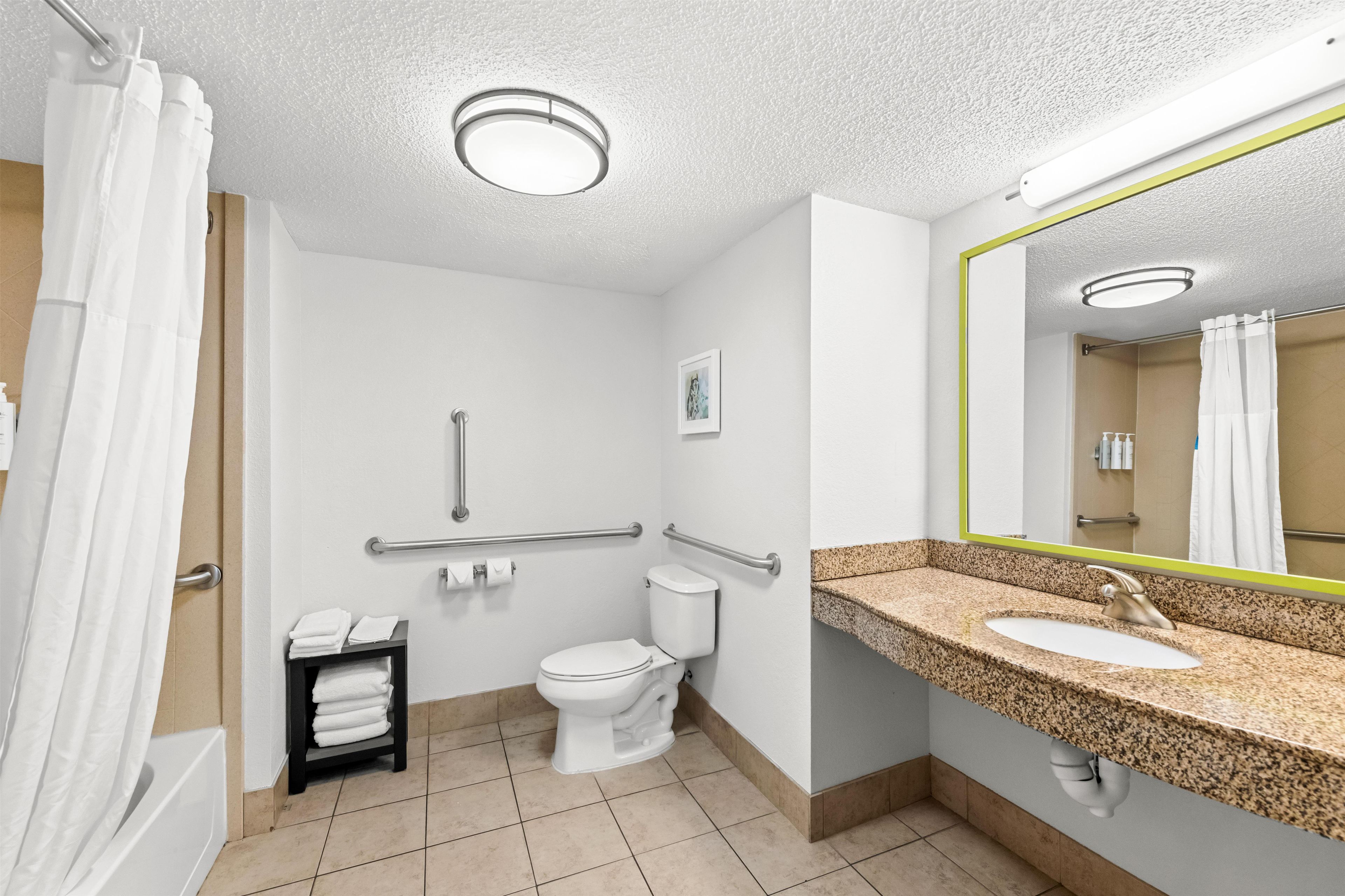 Un baño de hotel con inodoro, lavamanos y ducha.
