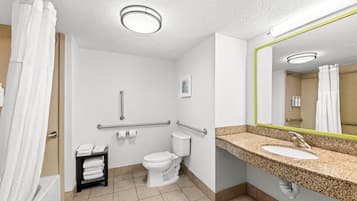 Un baño de hotel con inodoro, lavamanos y ducha.