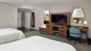 A hotel room with two beds, a TV, a desk with a chair, a mirror, and a lamp. - Hampton Inn & Suites Las Vegas Airport (Las Vegas)