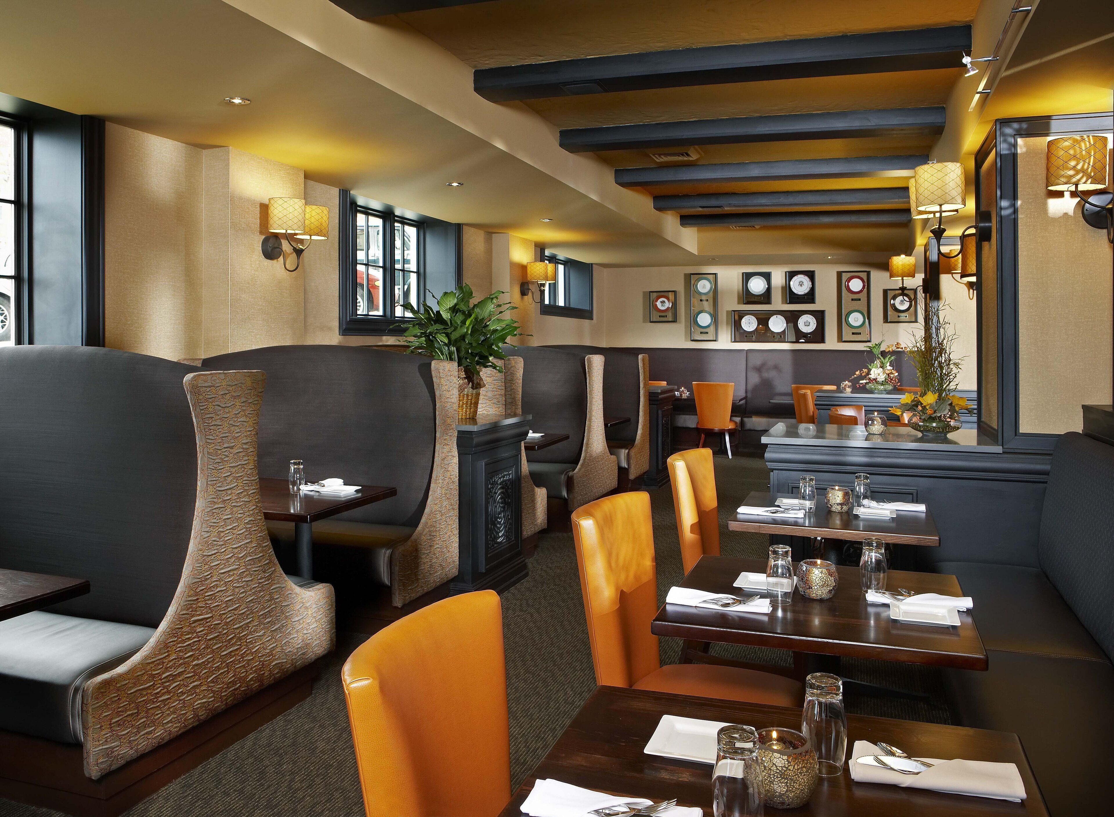 A restaurant with booths and tables, some with plants.