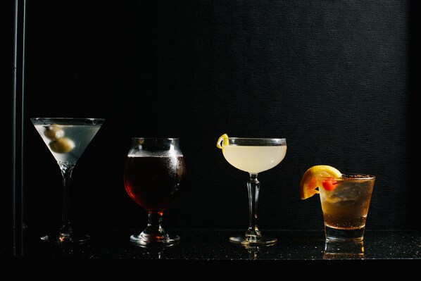Four different types of drinks in various glasses.