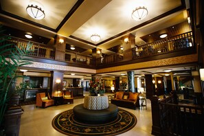 A spacious lobby with a central round table, multiple seating areas, and a balcony overlooking the lobby. - Hotel Julien Dubuque (Dubuque)
