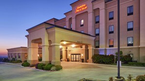Un hôtel Hampton Inn & Suites doté d’une entrée bien visible, d’une façade bien éclairée et d’un parterre aménagé à l’avant.