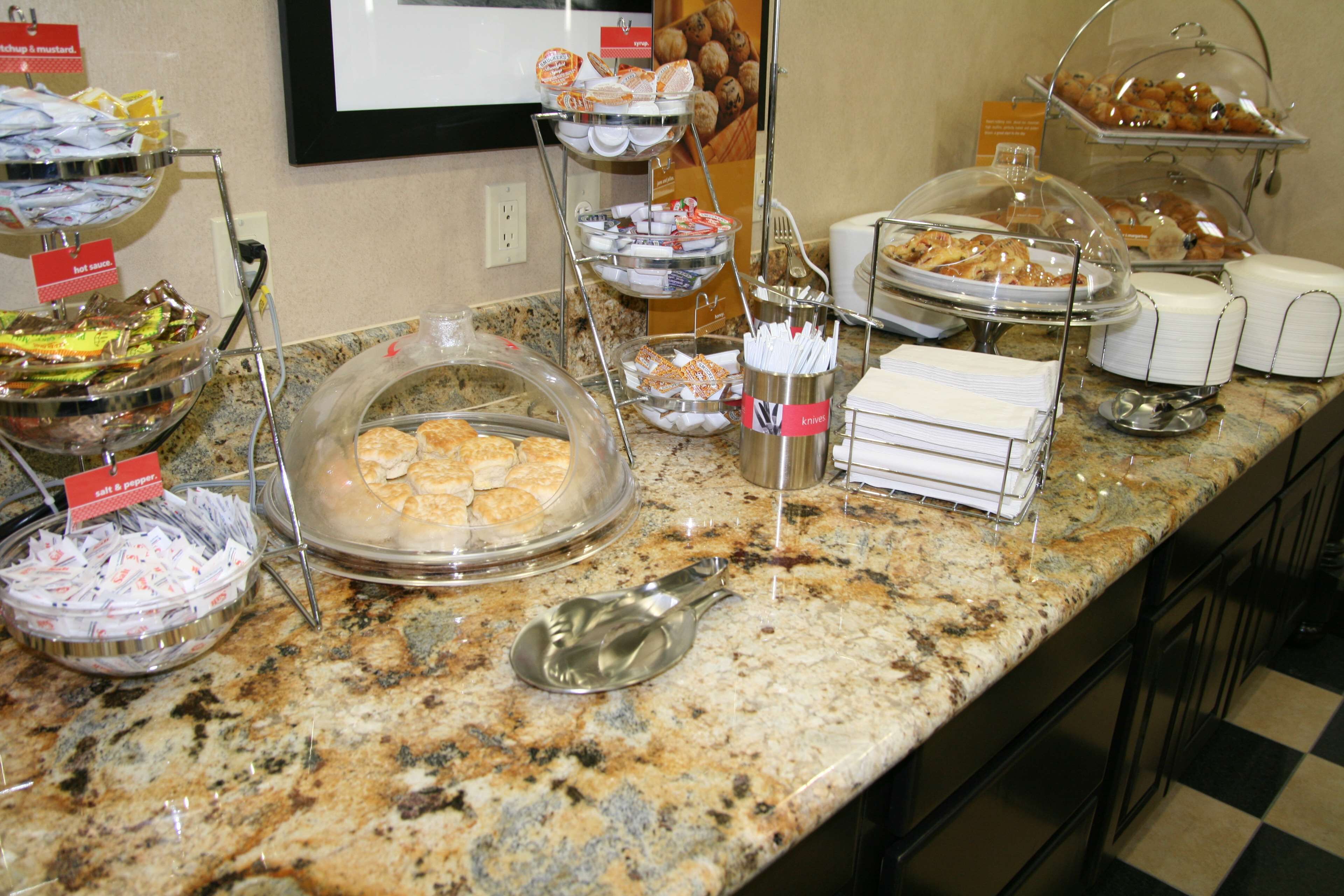 A buffet setup with various food items and condiments.