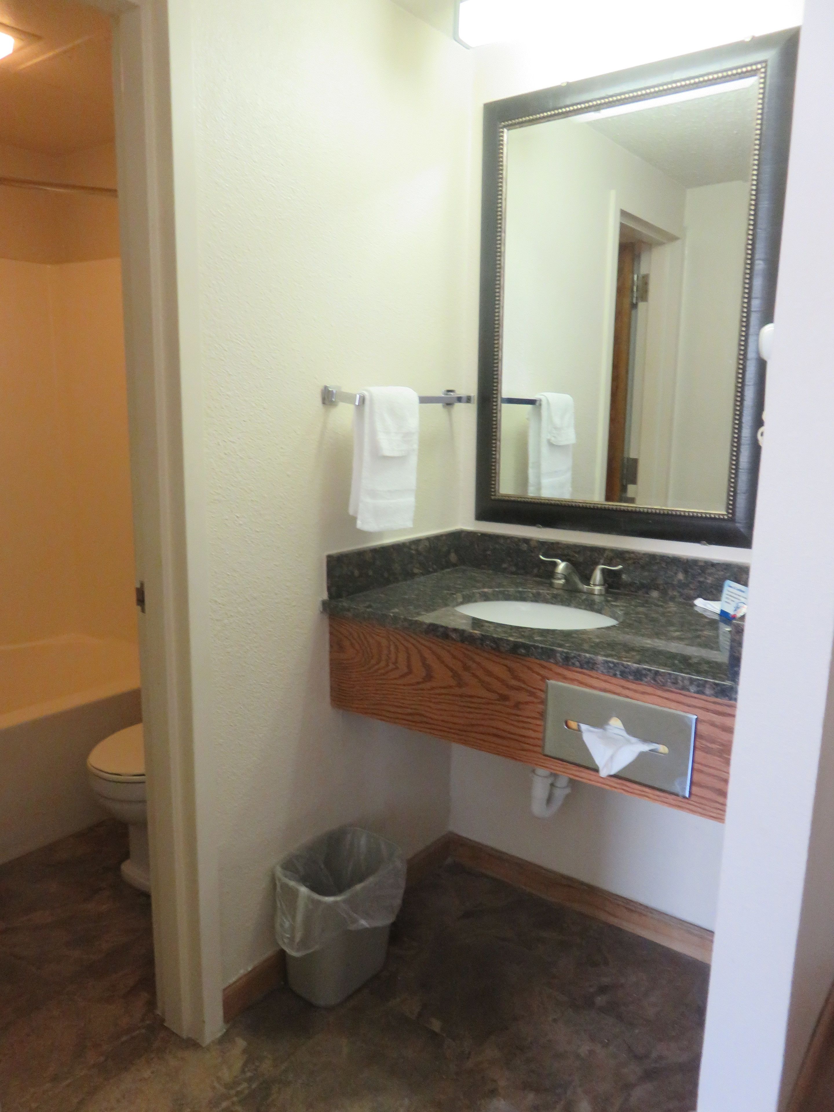 A bathroom with a sink, mirror, and towel rack.