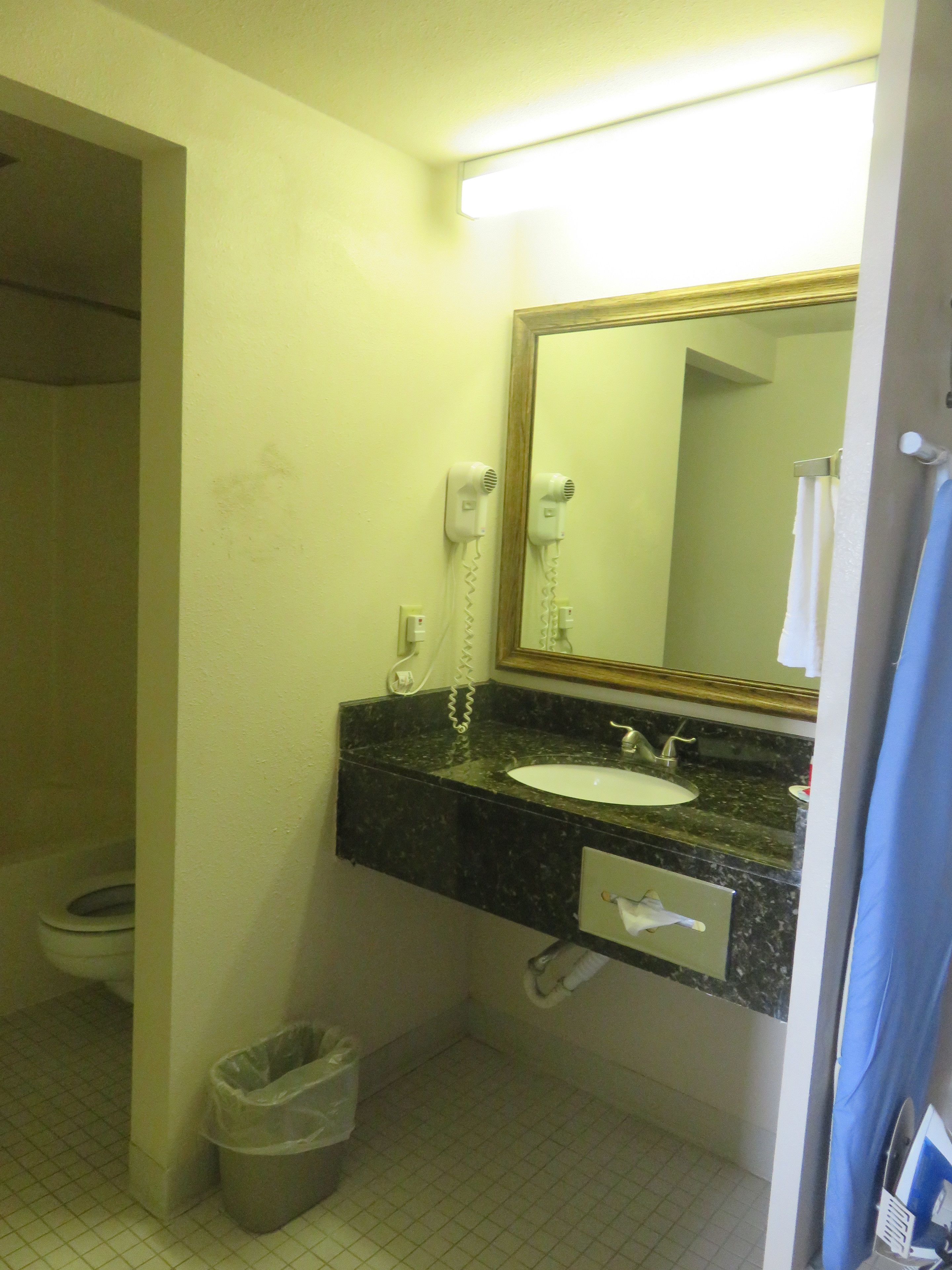 Un baño con lavabo, espejo y secador de pelo.