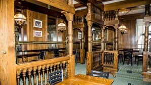 A traditional wooden interior with high wooden beams, chandeliers, and a patterned floor. - Baymont by Wyndham Fargo (Fargo)