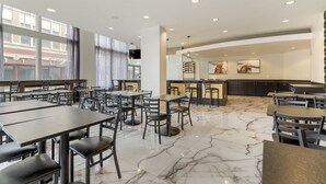 A modern restaurant with marble flooring, multiple dining tables and chairs, and large windows. - Hotel Gibbs Downtown Riverwalk (San Antonio)