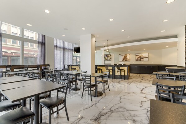 A modern restaurant with marble flooring, multiple dining tables and chairs, and large windows. - Hotel Gibbs Downtown Riverwalk (San Antonio)