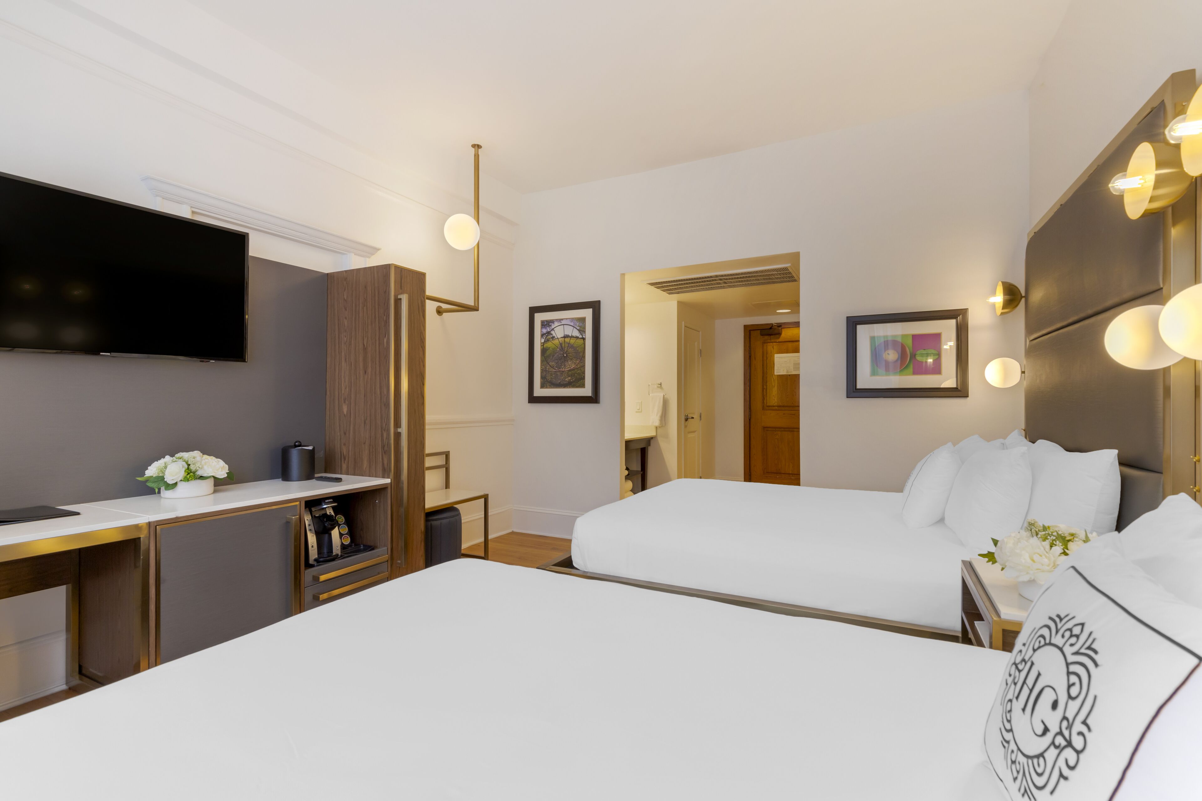Habitación de hotel con dos camas, un escritorio, un televisor de pantalla plana y un minibar.