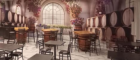 A restaurant with marble flooring, wooden tables and chairs, and wine barrels.