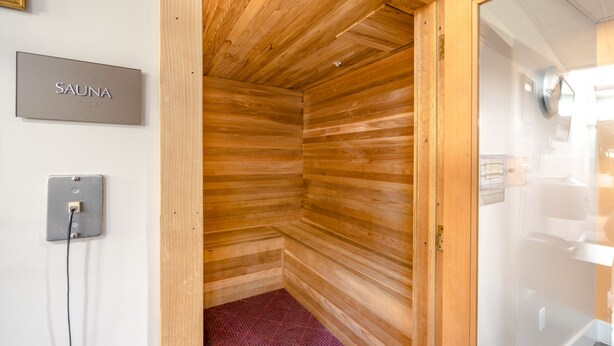 A sauna room with wooden walls and a sign labeled "SAUNA". - Hotel Gibbs Downtown Riverwalk (San Antonio)