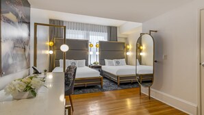 A modern hotel room with two beds, a desk with a vase of flowers, and a large mirror. - Hotel Gibbs Downtown Riverwalk (San Antonio)