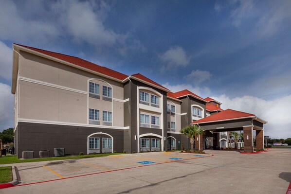 A multi-story hotel with a red roof, large windows, and a covered entrance area. - La Quinta Inn & Suites by Wyndham Port Lavaca (Port Lavaca)