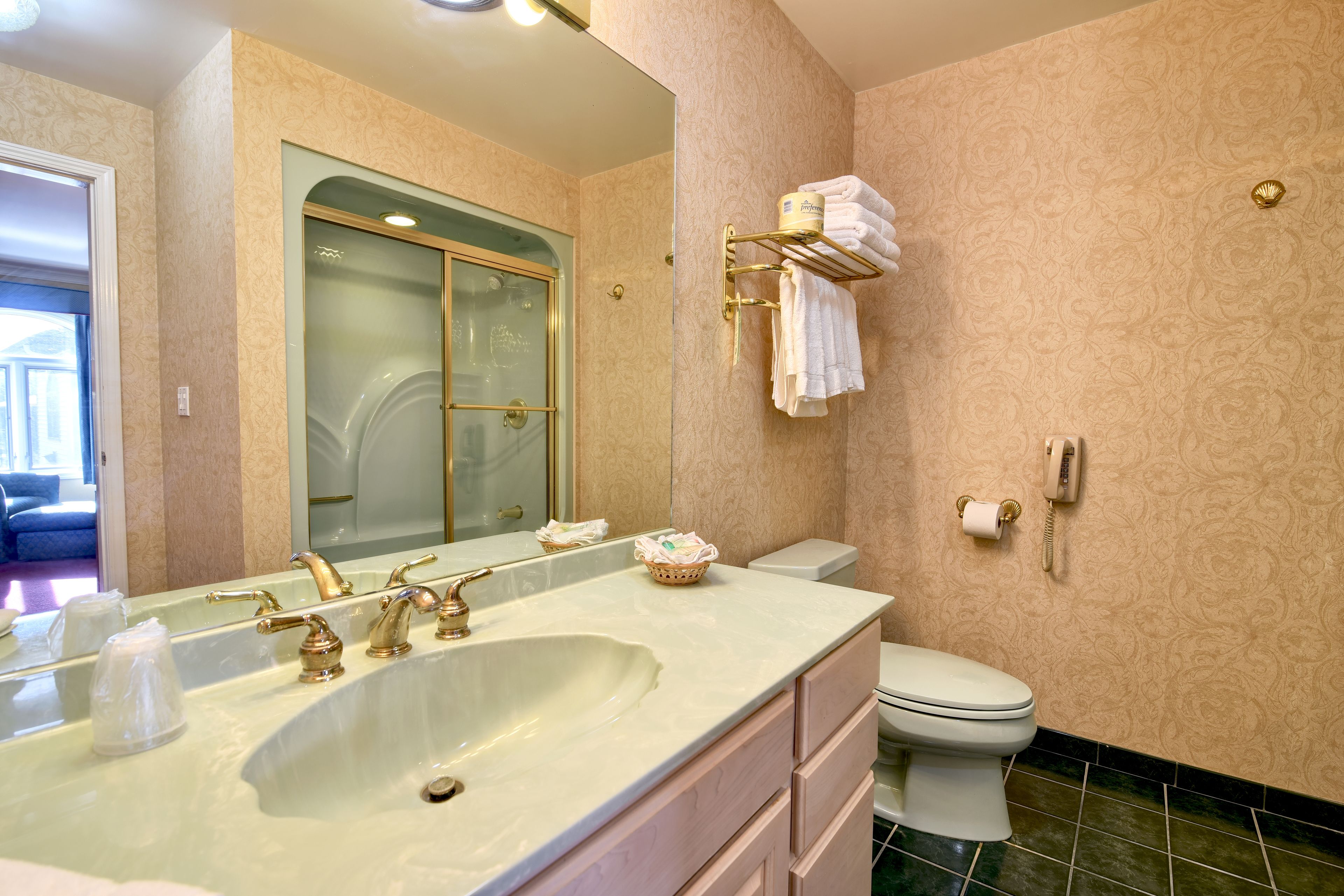 Un baño con un lavamanos grande, un inodoro y una puerta de ducha de vidrio.