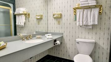 A bathroom with a sink, mirror, towel rack, and toilet.