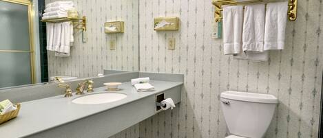 A bathroom with a sink, mirror, towel rack, and toilet.