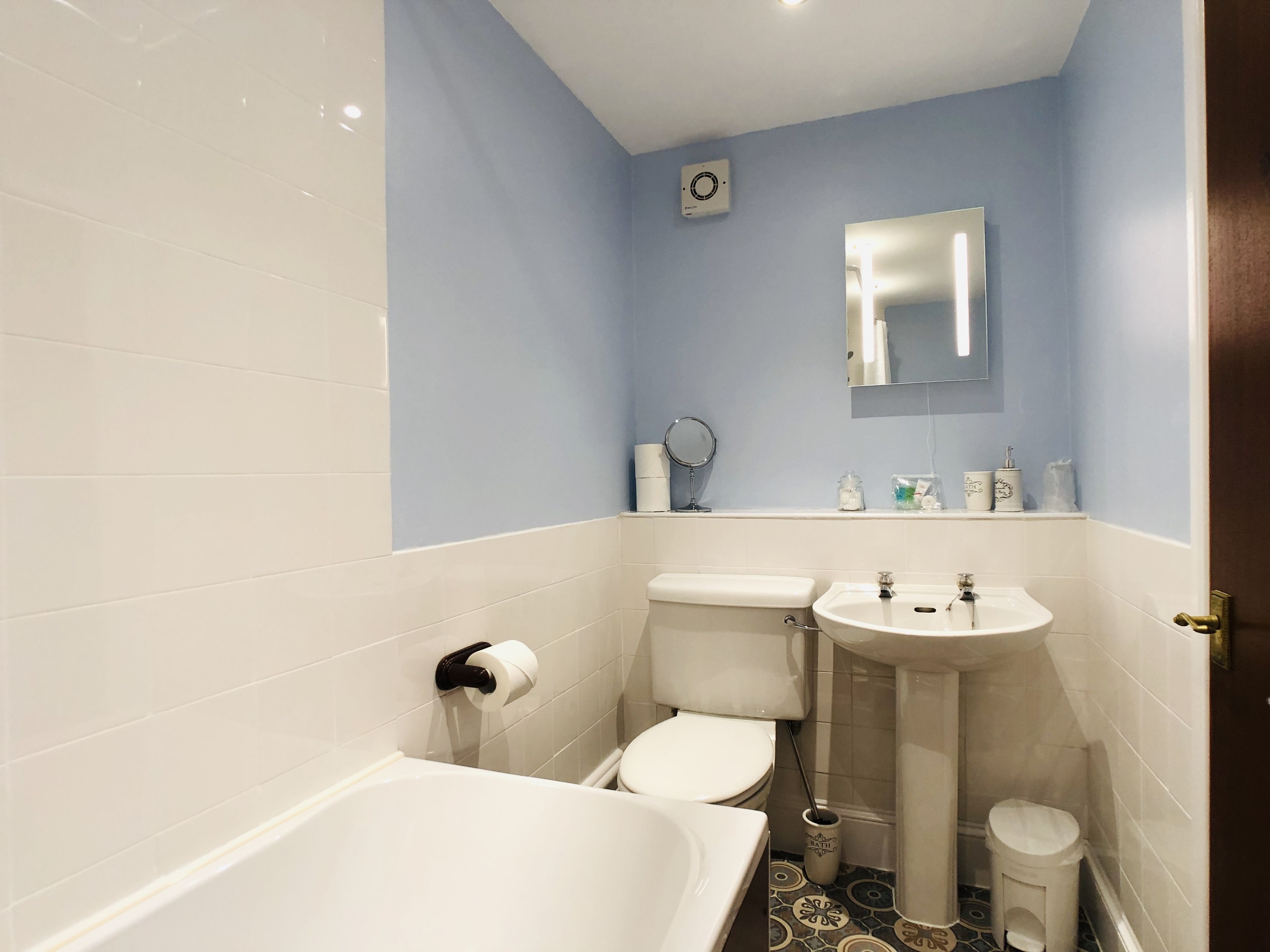 A bathroom with a bathtub, toilet, and sink.