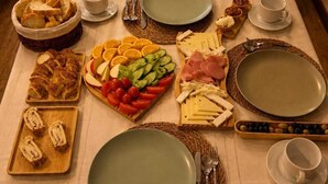 A table set with various food items, plates, and cutlery, suggesting a meal setting. - Villa Sphendone Suites (Istanbul)